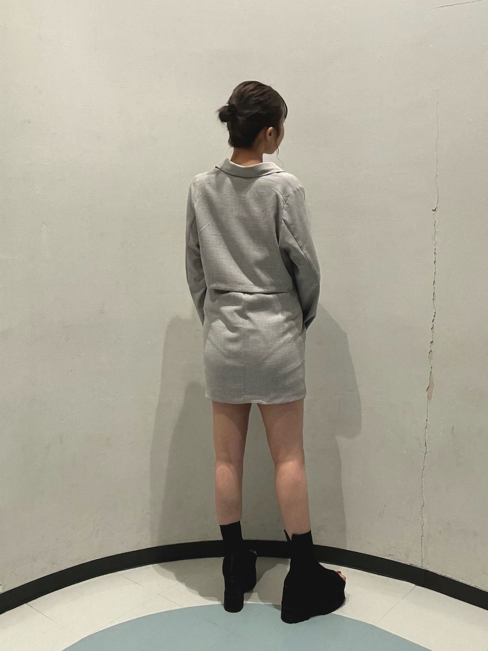 ブラック系のショルダーバッグ、グレー系のワンピース、ブラック系のブーツを着用したレディースの春コーディネートの4枚目の写真