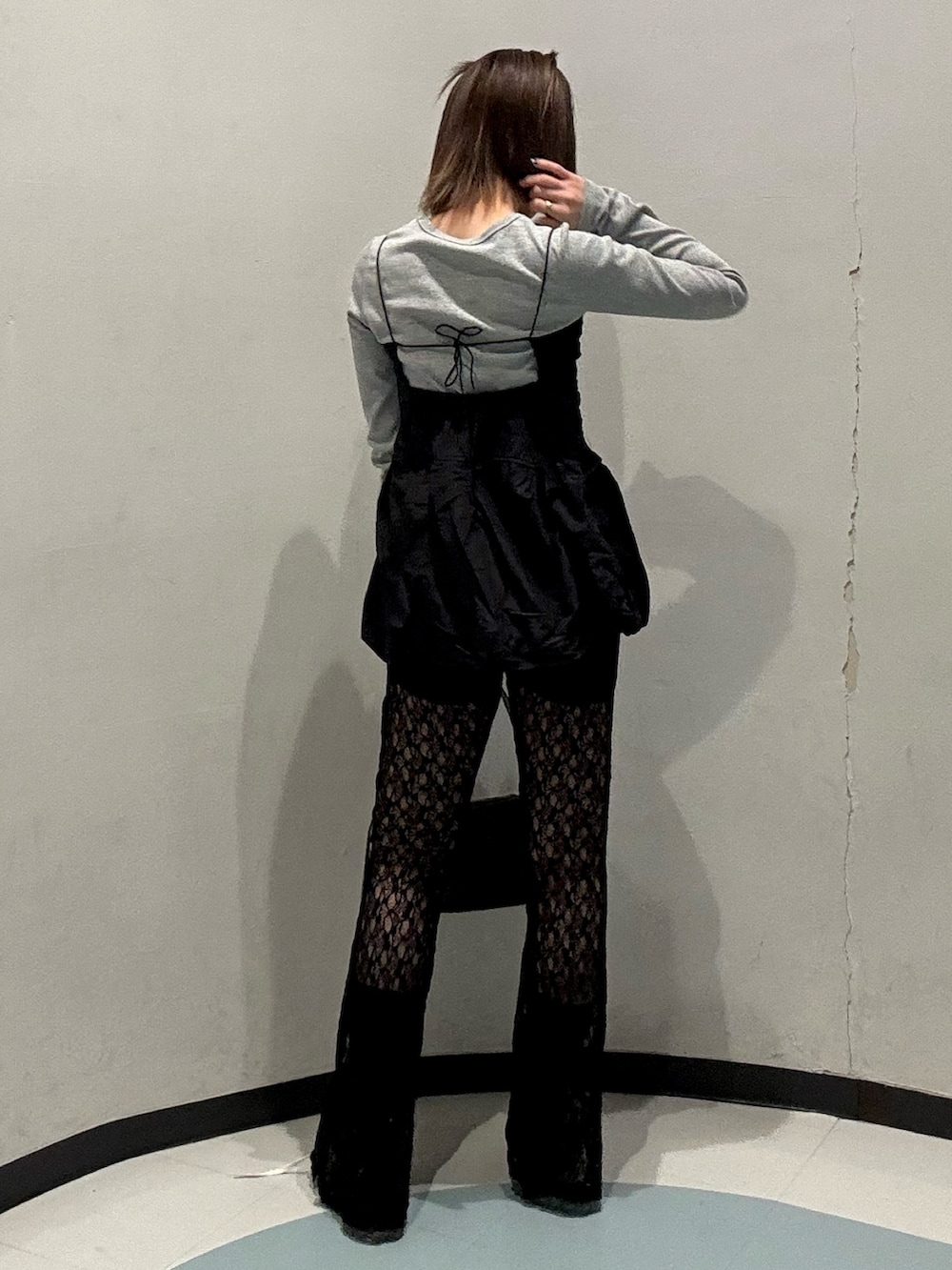 ブラック系のキャミソール、ブラウン系のハンドバッグ、グレー系のTシャツ/カットソーを着用したレディースの春コーディネートの3枚目の写真