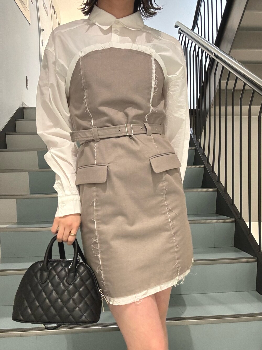 ベージュ系のワンピース、ブラック系のブーツ、ブラック系のハンドバッグを着用したレディースの冬コーディネートの4枚目の写真