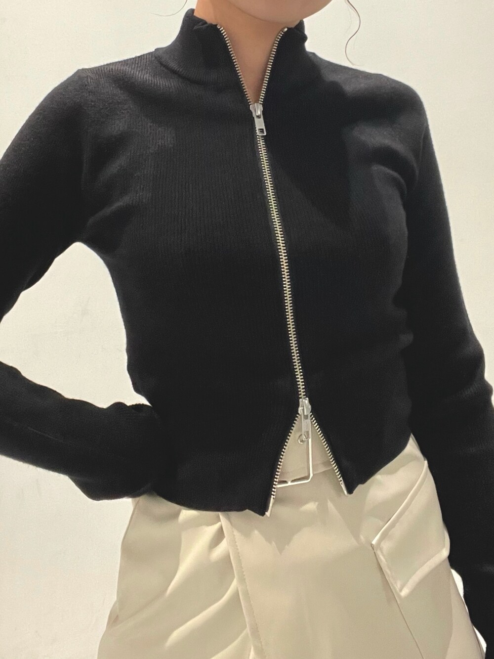 ホワイト系のスカート、ブラック系のニット/セーターを着用したレディースの秋コーディネートの5枚目の写真