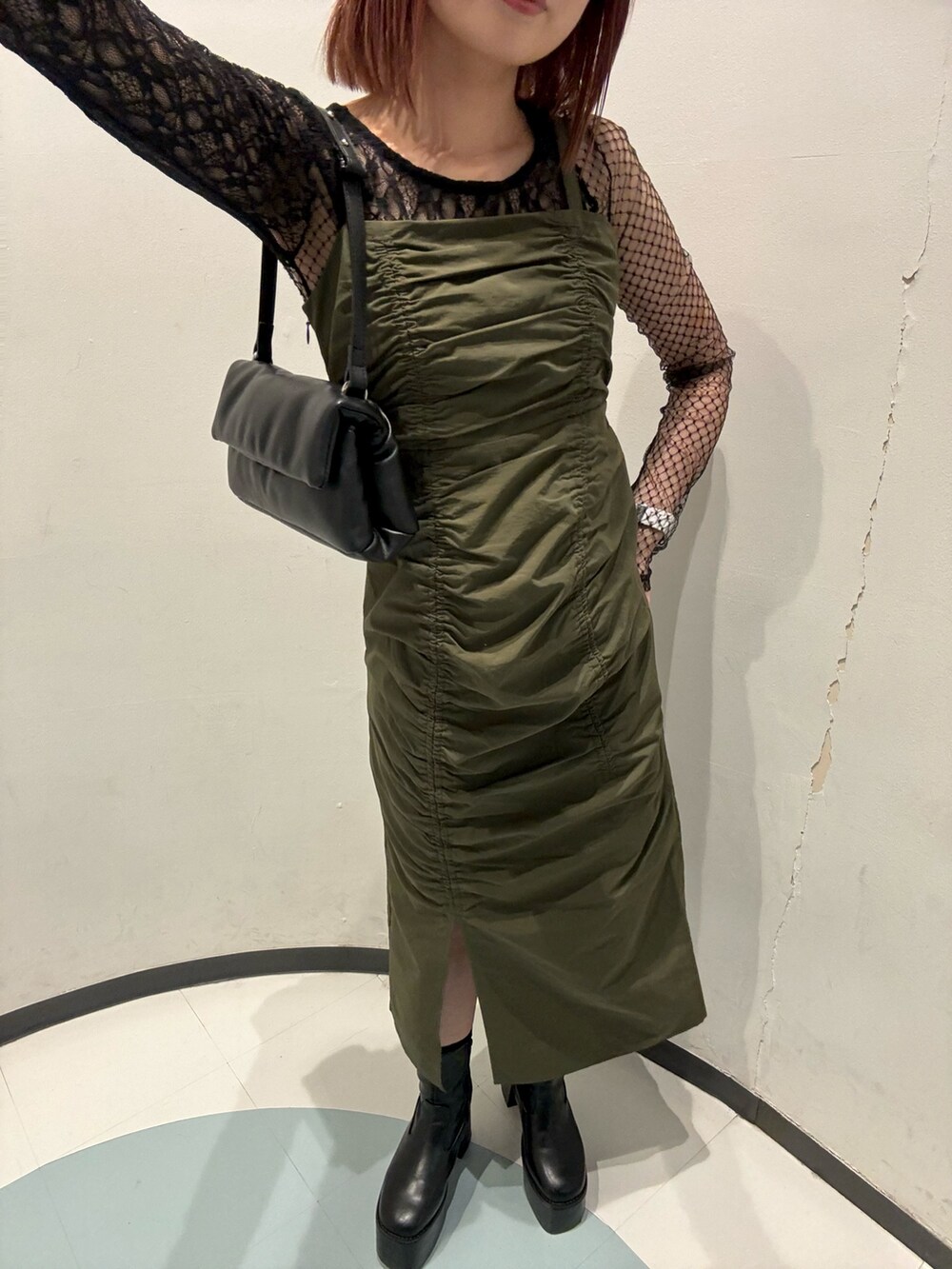 ブラック系のハンドバッグ、ブラック系のTシャツ/カットソー、ブラック系のブーツを着用したレディースの秋コーディネートの5枚目の写真