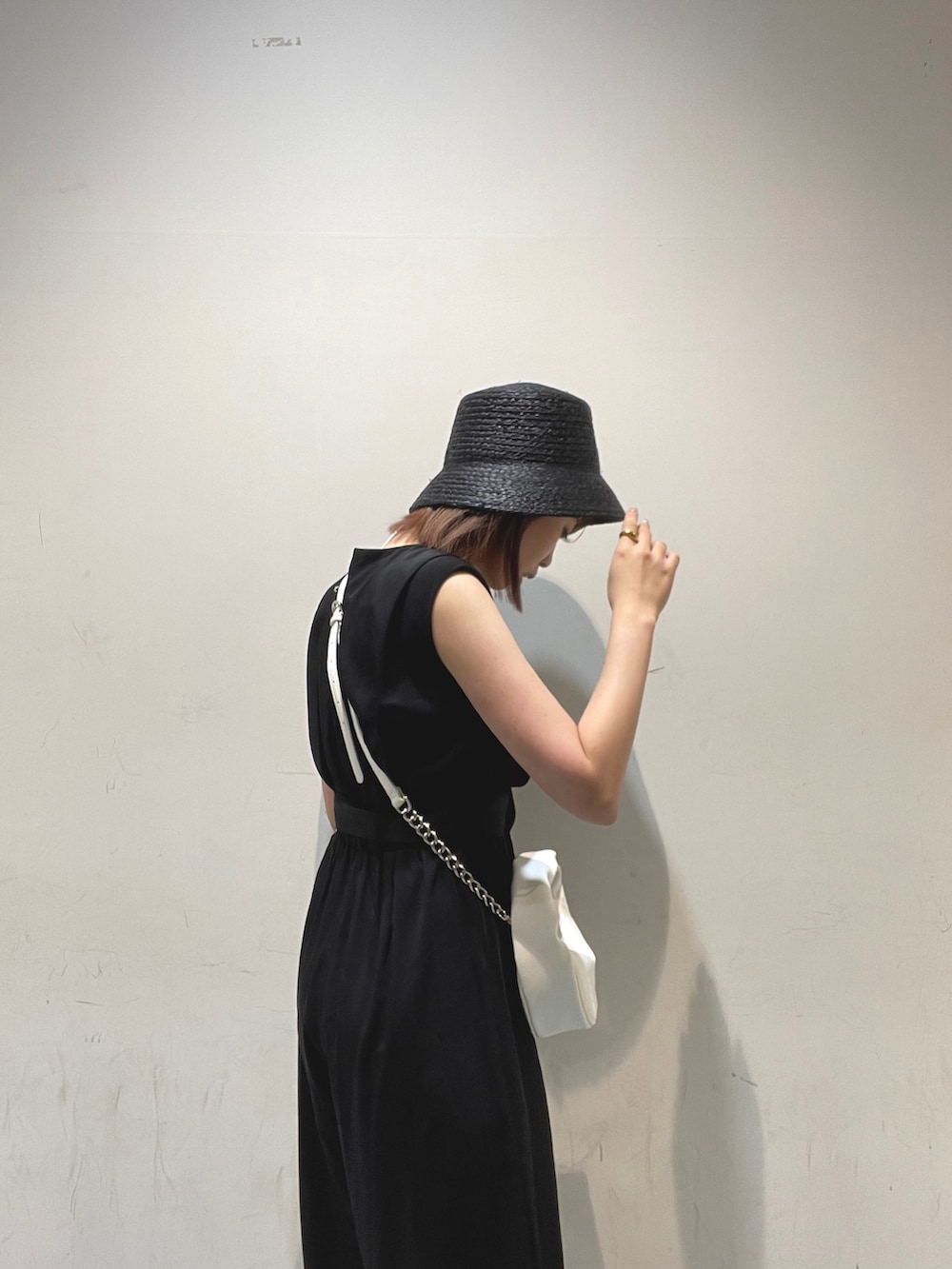 ホワイト系のハンドバッグ、ブラック系のサロペット/オーバーオールを着用したレディースの夏コーディネートの4枚目の写真