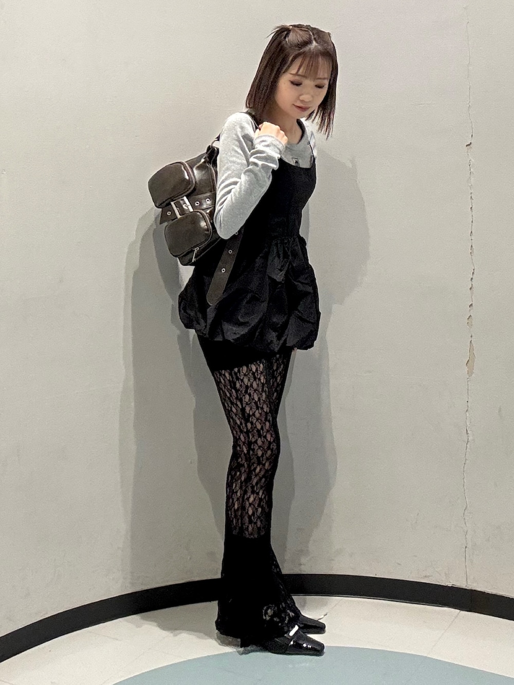 ブラック系のキャミソール、ブラウン系のハンドバッグ、グレー系のTシャツ/カットソーを着用したレディースの春コーディネートの2枚目の写真