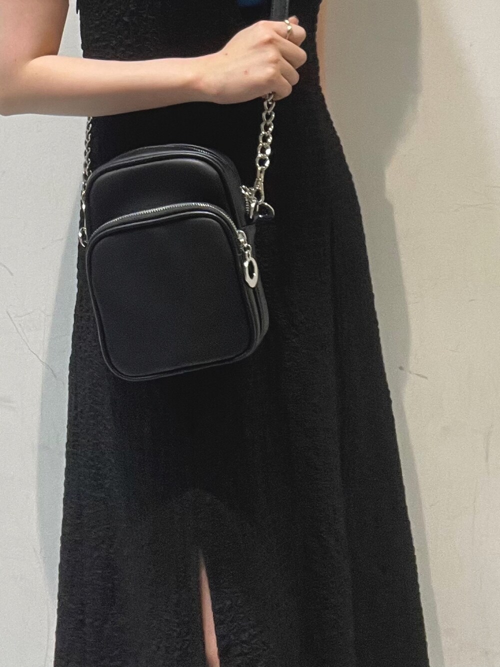 ブラック系のショルダーバッグ、ホワイト系のサンダル、ブルー系のタンクトップを着用したレディースの春コーディネートの5枚目の写真