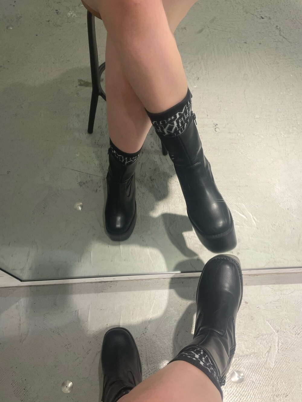 ブラック系のボストンバッグ、ブラック系のニット/セーター、ブラック系のブーツを着用したレディースの秋コーディネートの7枚目の写真