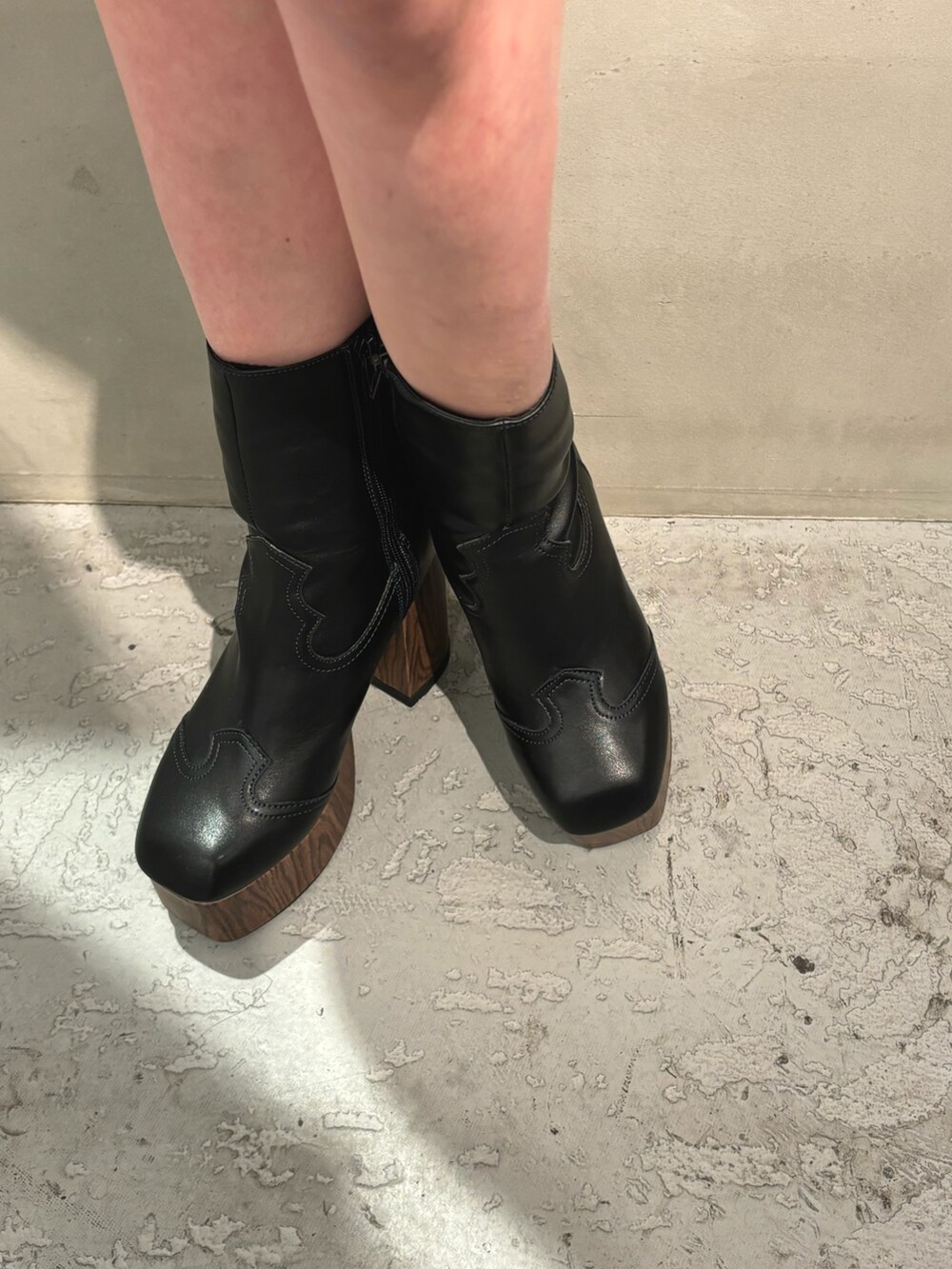 ブラック系のブーツ、ブラウン系のスカート、ブラック系のニット/セーターを着用したレディースの冬コーディネートの7枚目の写真