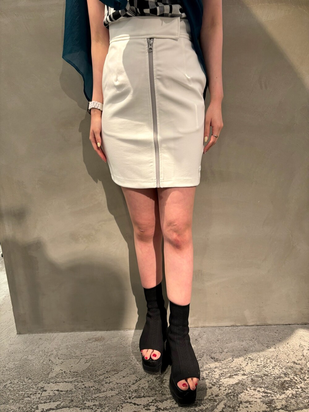 ブラック系のブーツ、ホワイト系のスカート、グリーン系のシャツ/ブラウスを着用したレディースの春コーディネートの7枚目の写真