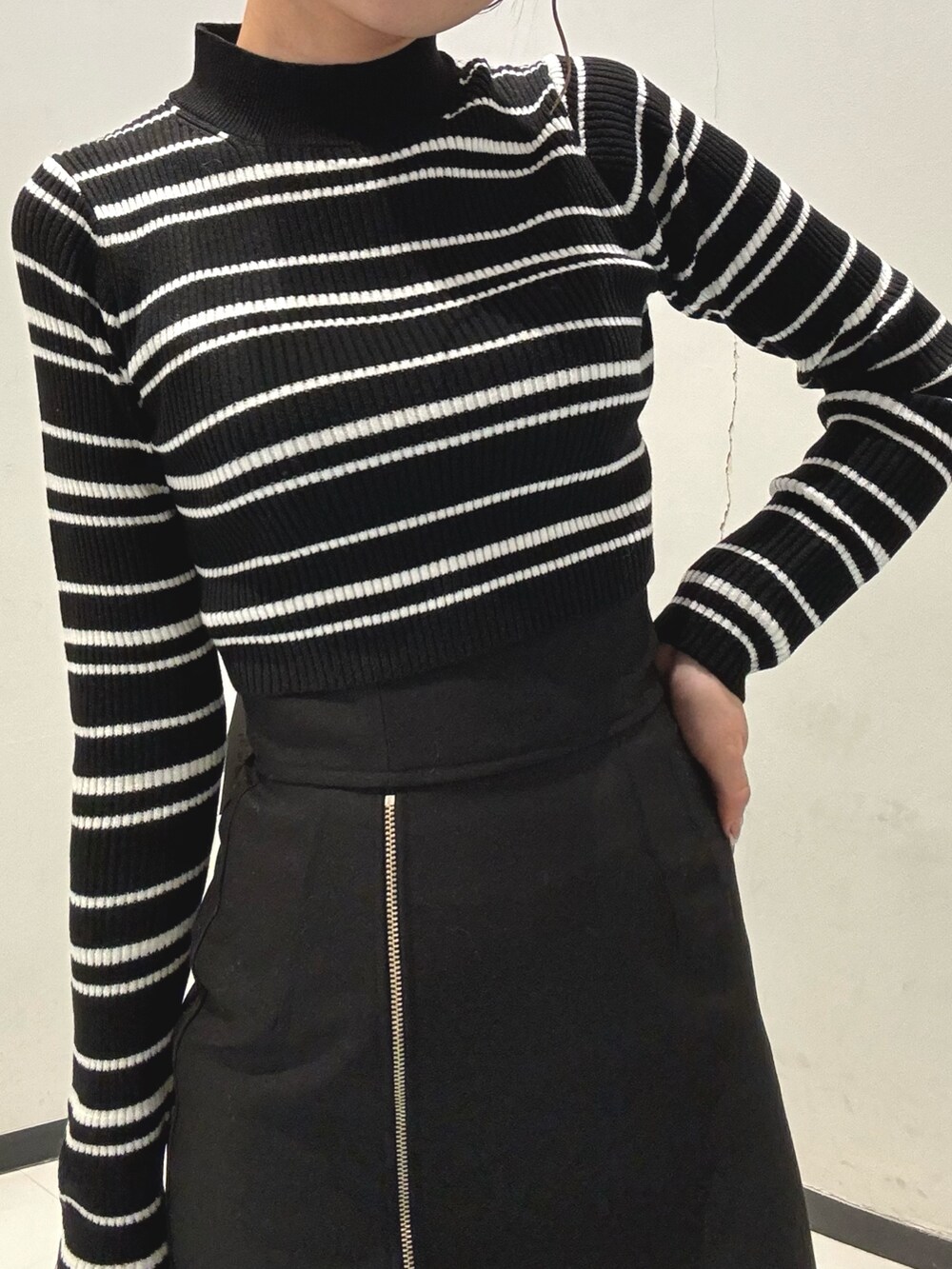 ブラック系のスカート、その他のニット/セーター、ブラウン系のムートンコートを着用したレディースの秋コーディネートの6枚目の写真