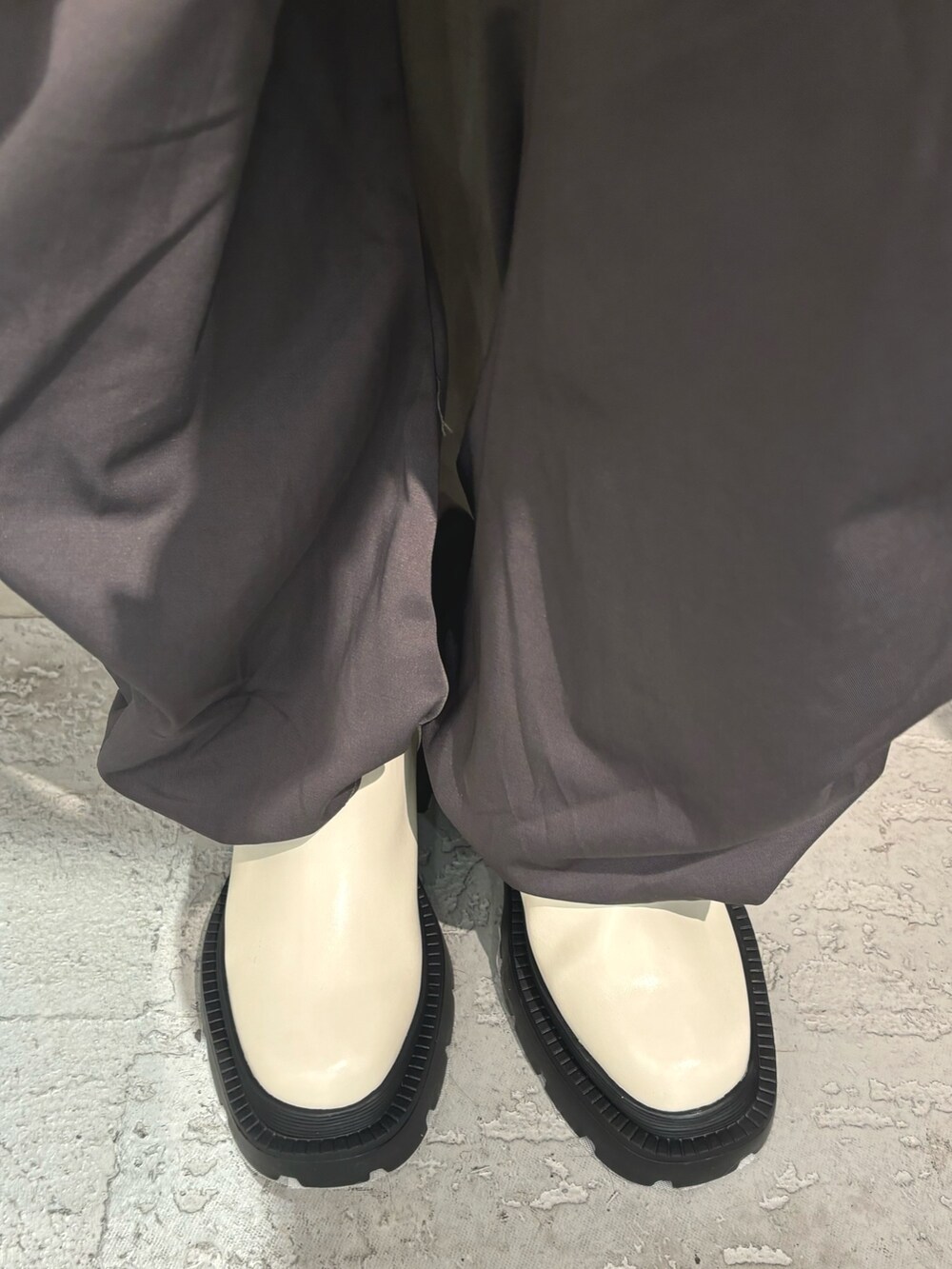 ホワイト系のブーツ、ブラック系のニット/セーター、グレー系のカーゴパンツを着用したレディースの冬コーディネートの7枚目の写真