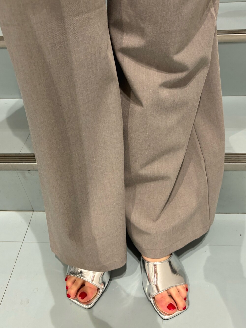 グレー系のワンピース、ブラック系のショルダーバッグ、シルバー系のサンダルを着用したレディースの春コーディネートの7枚目の写真