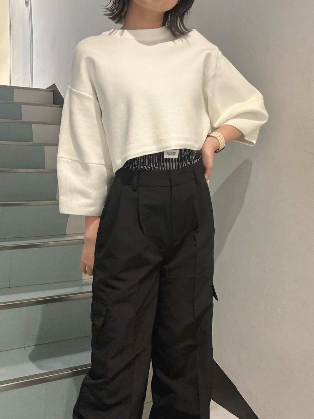 ブルー系のニット/セーター、ブラック系のその他パンツ、ブラック系のブーツを着用したレディースの冬コーディネートの4枚目の写真