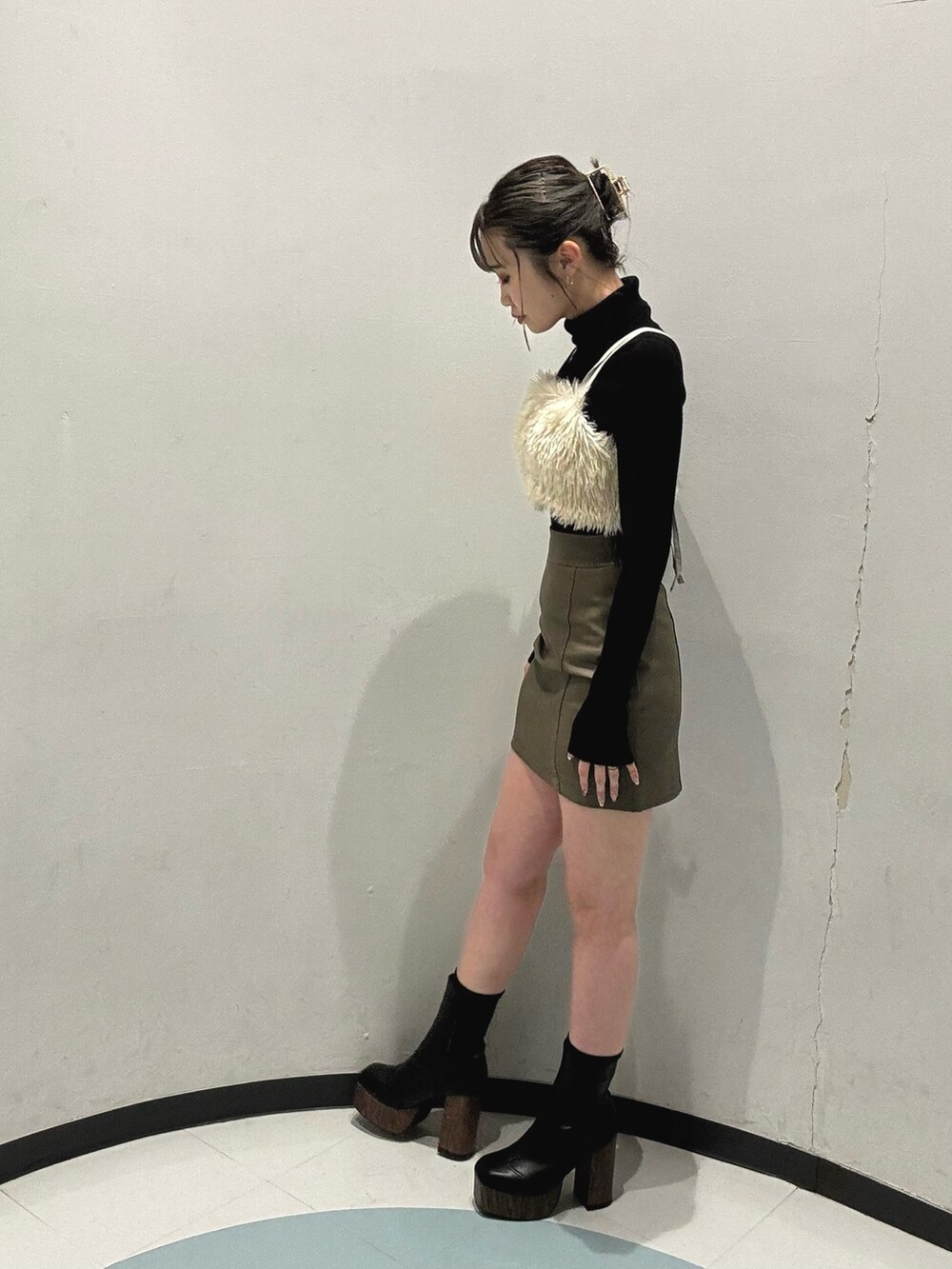 ブラック系のブーツ、ブラウン系のスカート、ブラック系のニット/セーターを着用したレディースの冬コーディネートの4枚目の写真