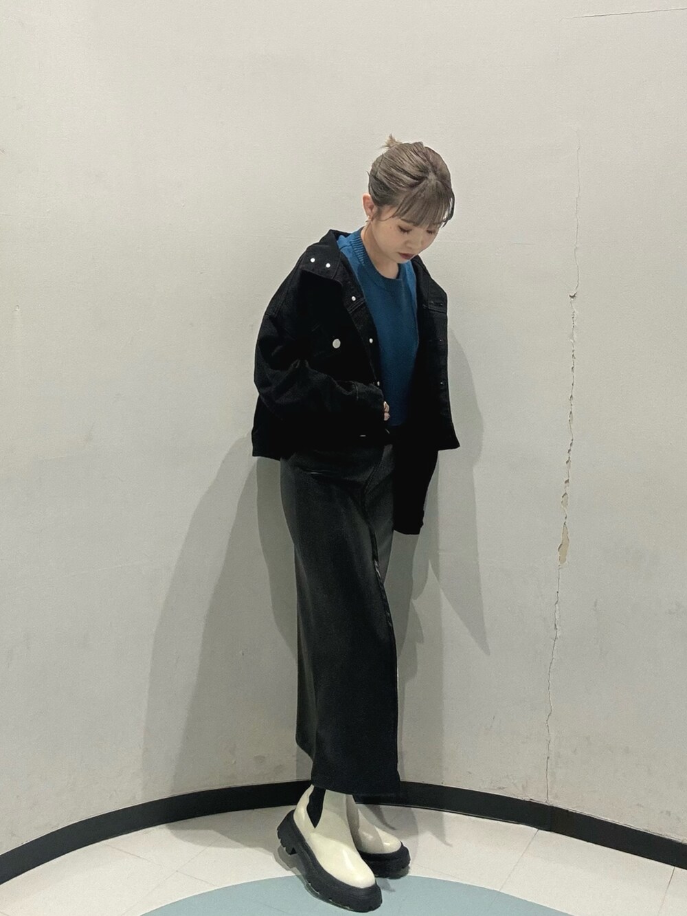 ホワイト系のブーツ、ブラック系のスカート、ブルー系のニット/セーターを着用したレディースの冬コーディネートの2枚目の写真