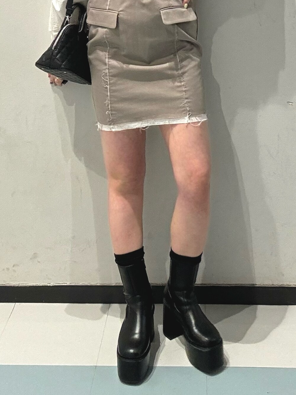 ベージュ系のワンピース、ブラック系のブーツ、ブラック系のハンドバッグを着用したレディースの冬コーディネートの5枚目の写真