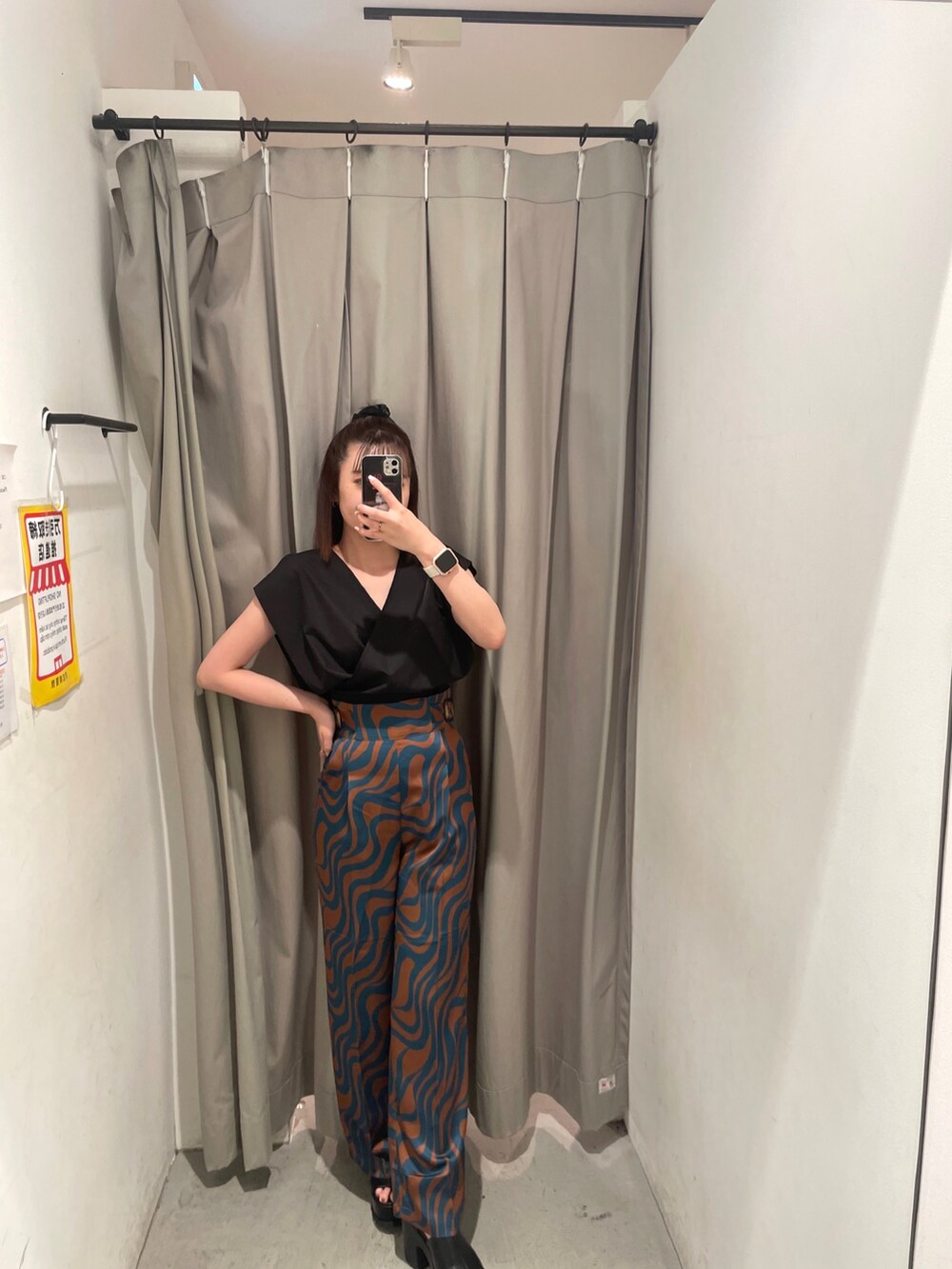 ブラック系のシャツ/ブラウス、ブルー系のスラックス、ホワイト系のハンドバッグを着用したレディースの夏コーディネートの2枚目の写真