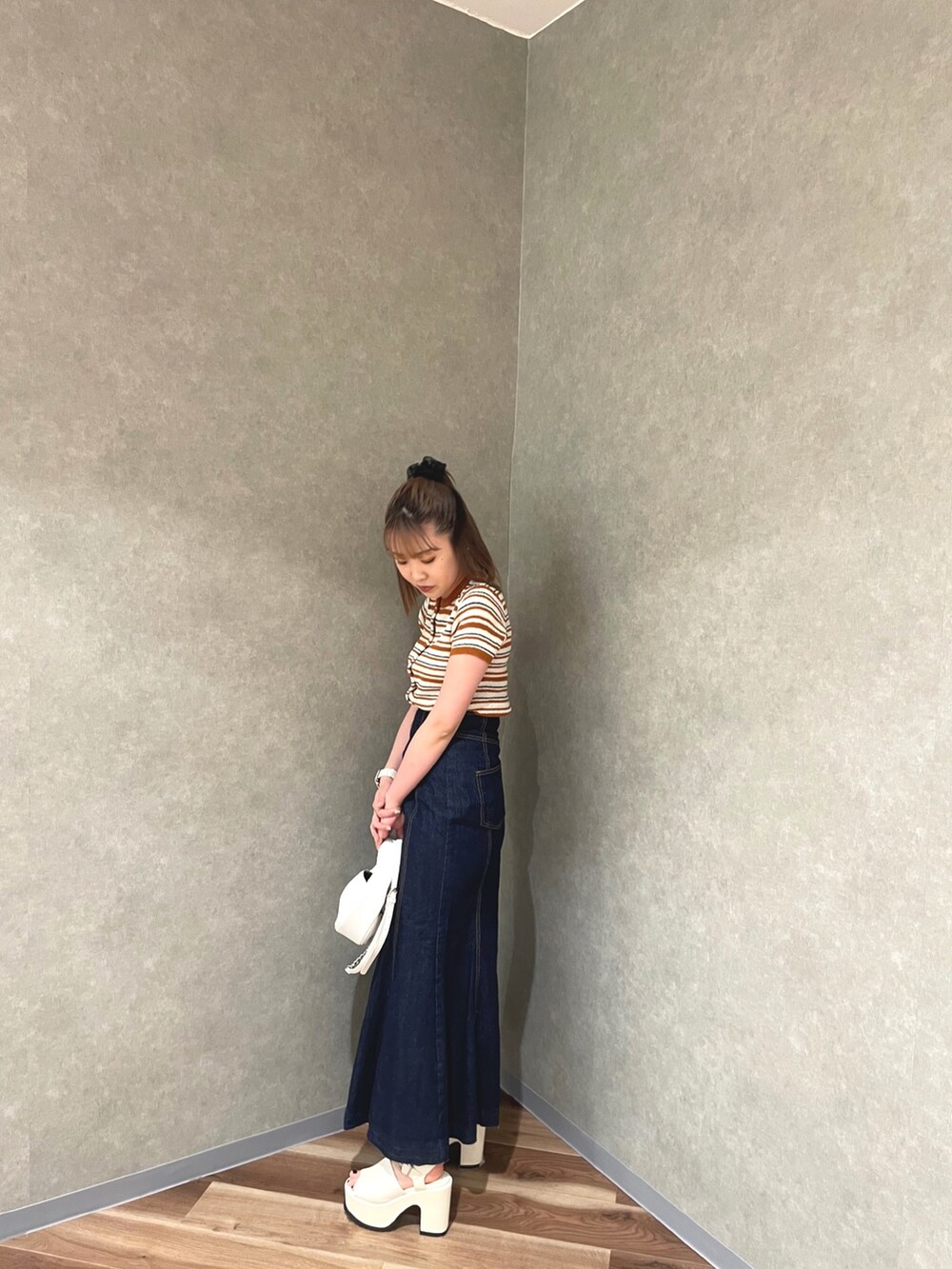 オレンジ系のカーディガン/ボレロ、ホワイト系のデニムスカート、ホワイト系のサンダルを着用したレディースの春コーディネートの3枚目の写真