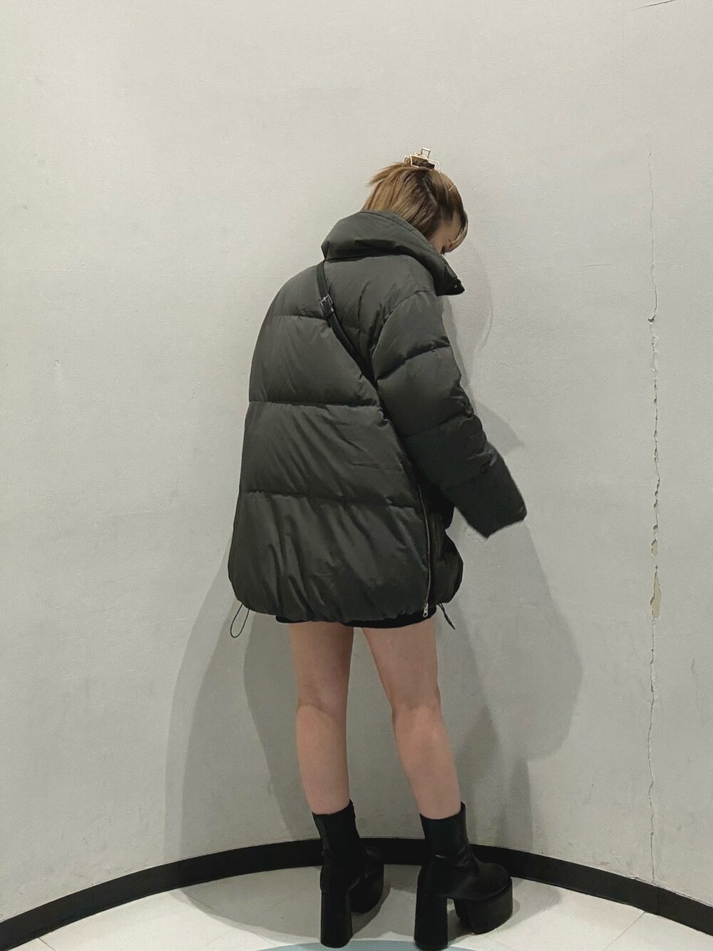 グレー系のダウンジャケット/コート、ホワイト系のニット/セーター、ブラック系のショルダーバッグを着用したレディースの秋コーディネートの4枚目の写真