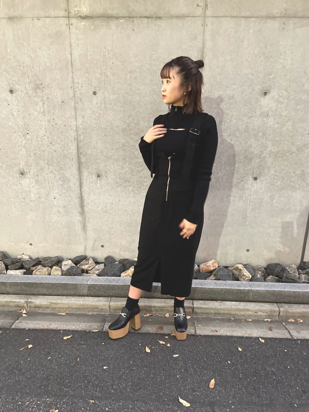 ブラック系のニット/セーター、ブラック系のジャンパースカート、その他のダウンジャケット/コートを着用したレディースの秋コーディネートの3枚目の写真