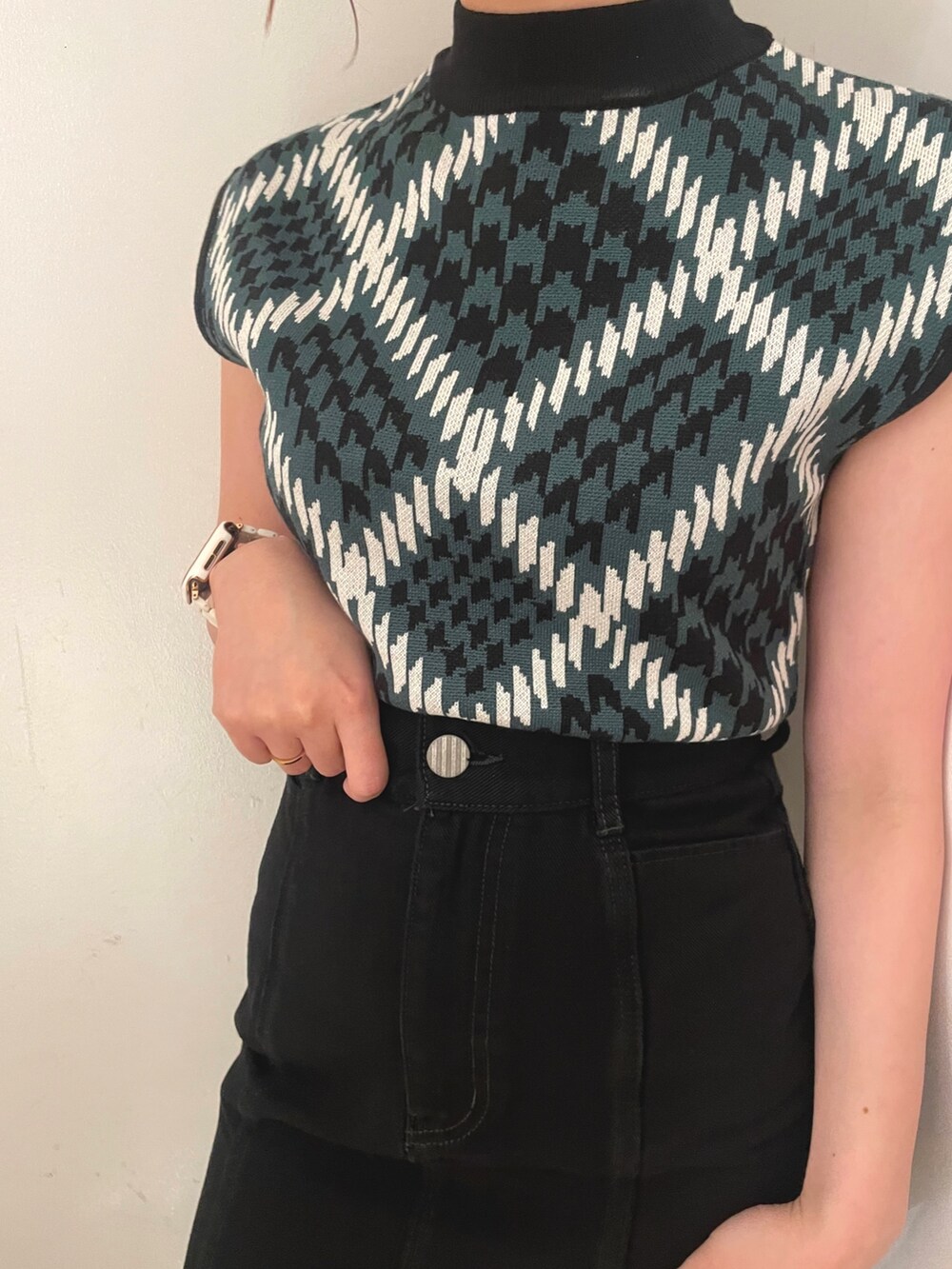 ブラック系のスカート、ブラック系のブーツ、グリーン系のニット/セーターを着用したレディースの夏コーディネートの6枚目の写真