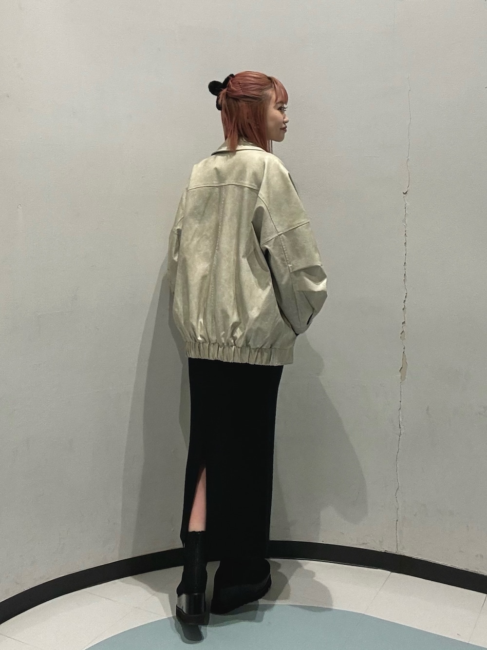 グリーン系のニット/セーター、ホワイト系のブルゾン、ブラック系のスカートを着用したレディースの冬コーディネートの5枚目の写真