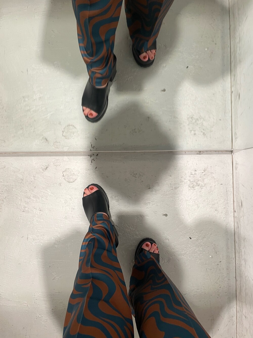 ブラック系のシャツ/ブラウス、ブルー系のスラックス、ホワイト系のハンドバッグを着用したレディースの夏コーディネートの6枚目の写真