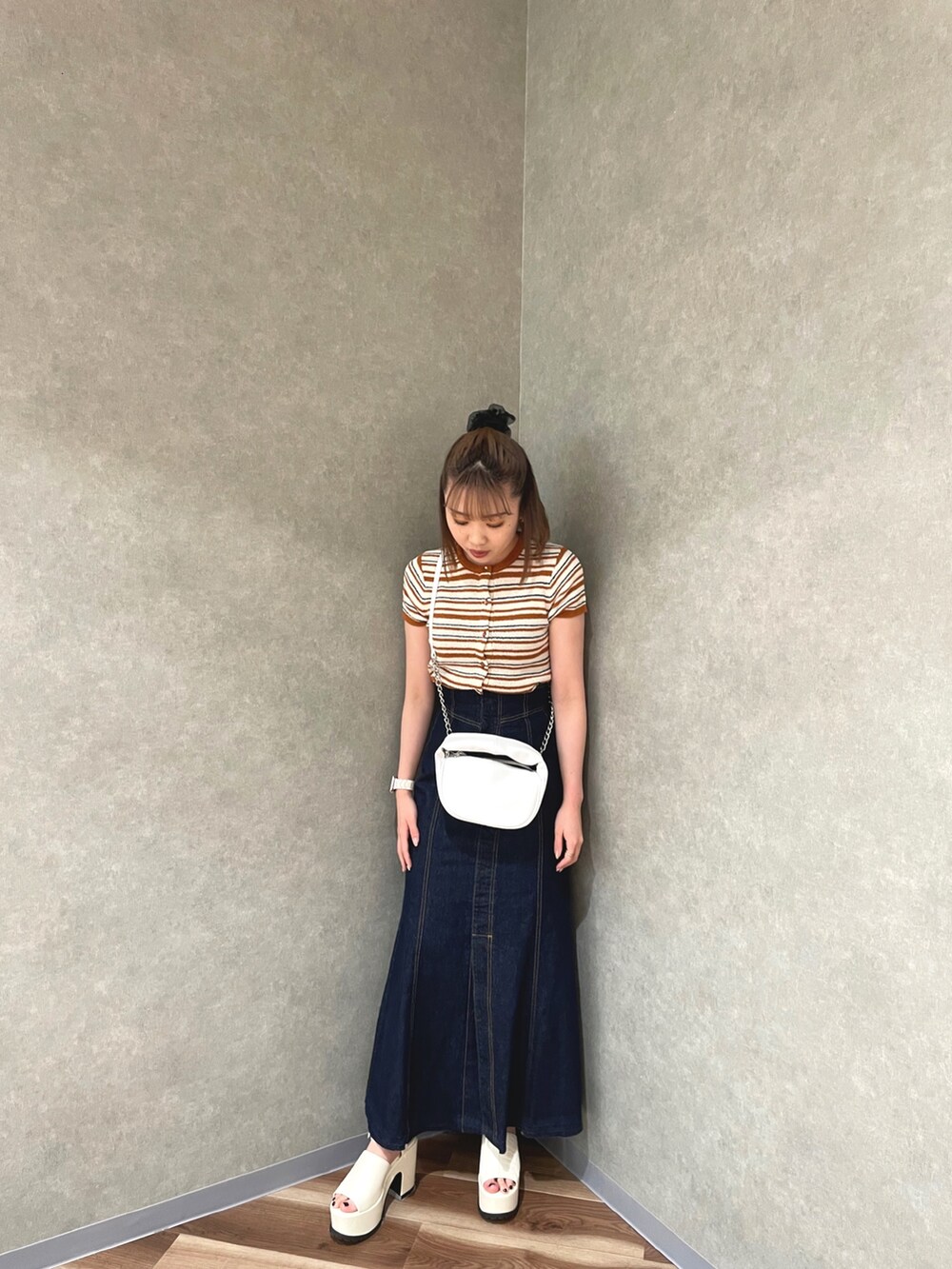 オレンジ系のカーディガン/ボレロ、ホワイト系のデニムスカート、ホワイト系のサンダルを着用したレディースの春コーディネートの2枚目の写真