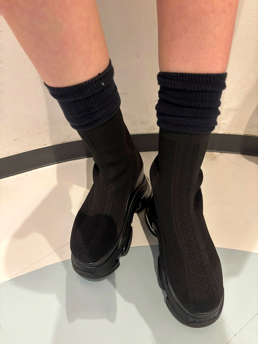 ブラック系のショルダーバッグ、ベージュ系のスカート、ベージュ系のブルゾンを着用したレディースの春コーディネートの7枚目の写真