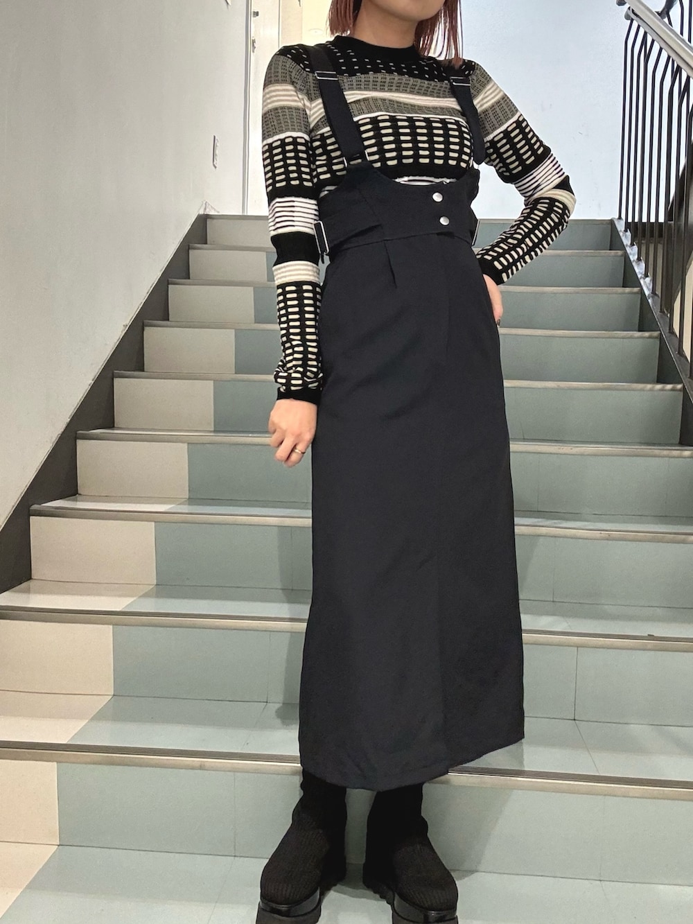 ブルー系のワンピース、ブラック系のハンドバッグ、ブラック系のブーツを着用したレディースの冬コーディネートの4枚目の写真