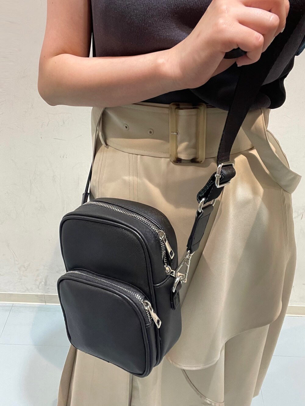 ホワイト系のジャンパースカート、ブルー系のニット/セーター、ブラック系のショルダーバッグを着用したレディースの夏コーディネートの5枚目の写真