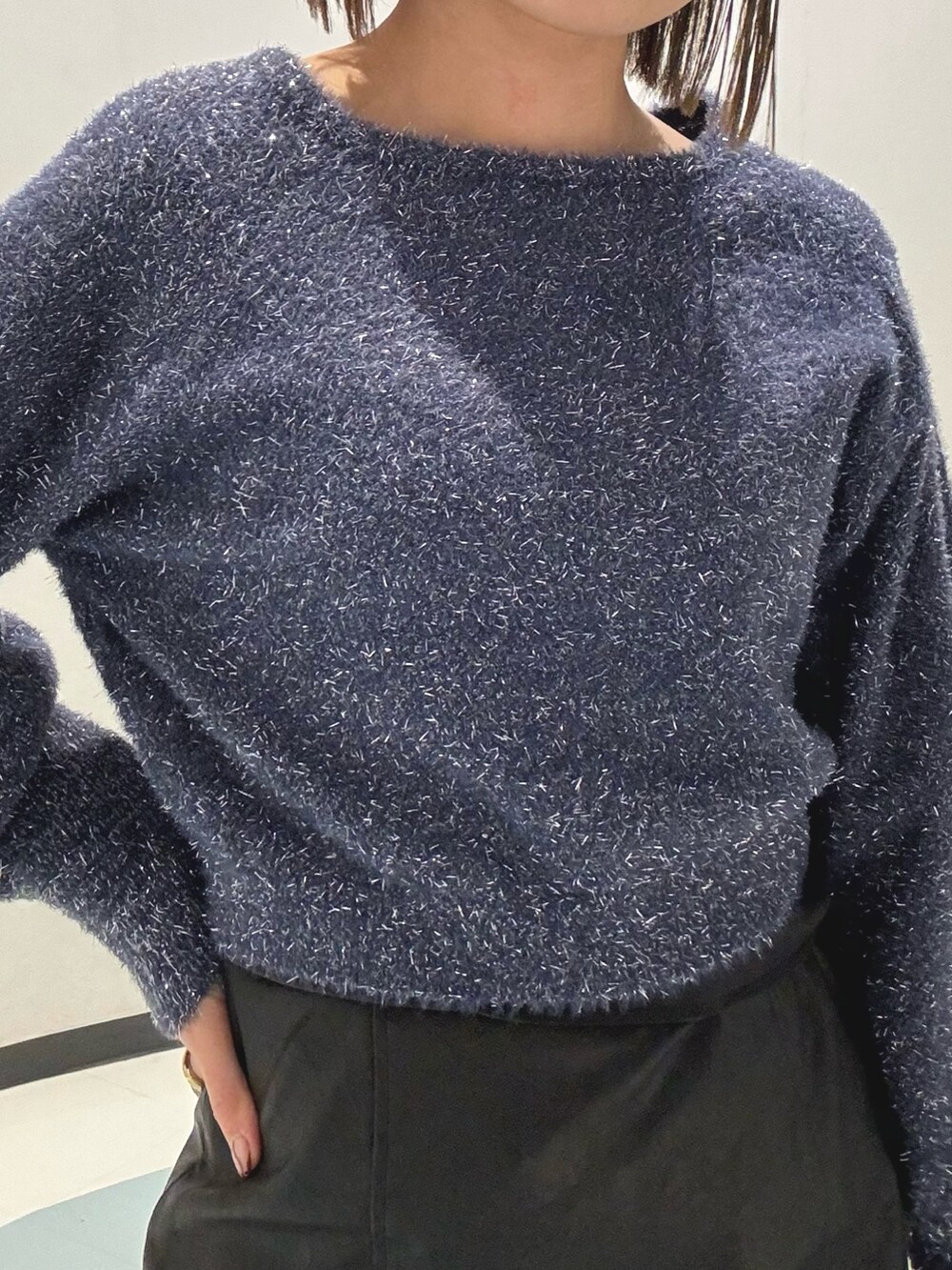 ブルー系のニット/セーター、ホワイト系のブルゾン、ブラック系のスカートを着用したレディースの冬コーディネートの5枚目の写真