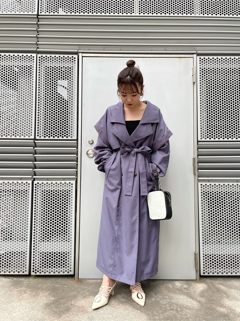 ブラック系のニット/セーター、ブラック系のスカート、ホワイト系のパンプスを着用したレディースの夏コーディネートの2枚目の写真