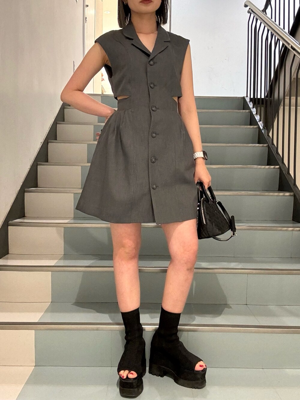 ブラック系のハンドバッグ、グレー系のワンピースを着用したレディースの春コーディネートの5枚目の写真