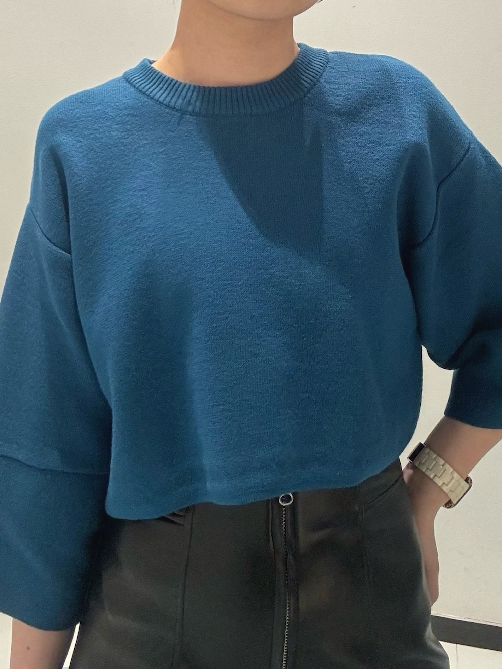 ホワイト系のブーツ、ブラック系のスカート、ブルー系のニット/セーターを着用したレディースの冬コーディネートの6枚目の写真