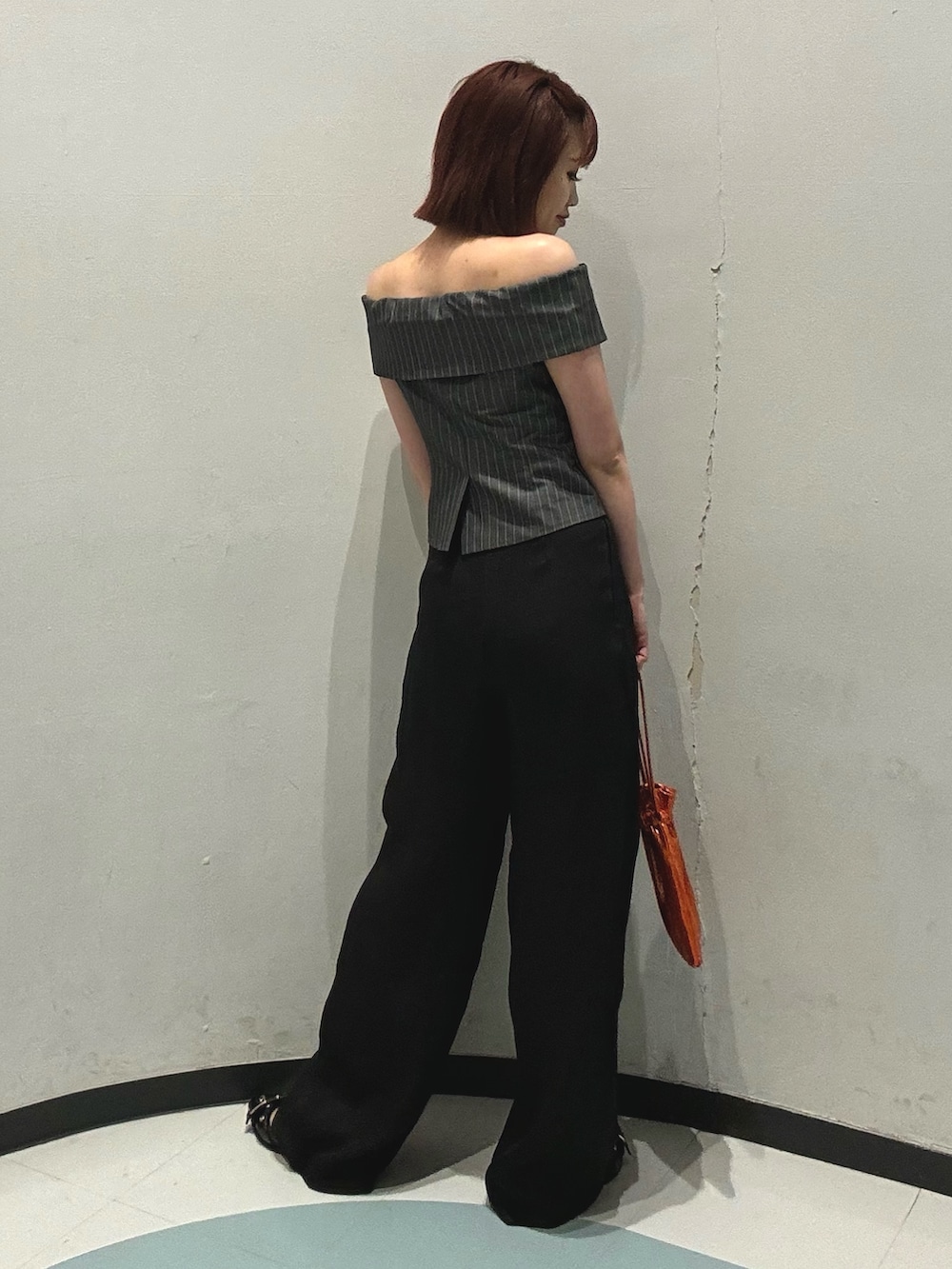 オレンジ系のショルダーバッグ、ブラック系のパンプス、ブラック系のその他パンツを着用したレディースの夏コーディネートの2枚目の写真