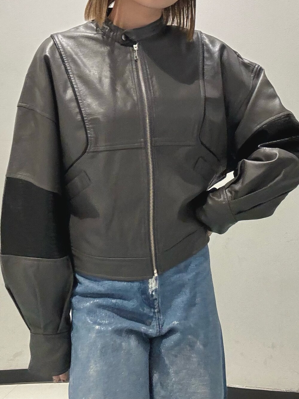 ブルー系のデニムパンツ、ブラック系のショルダーバッグ、グレー系のブルゾンを着用したレディースの冬コーディネートの7枚目の写真