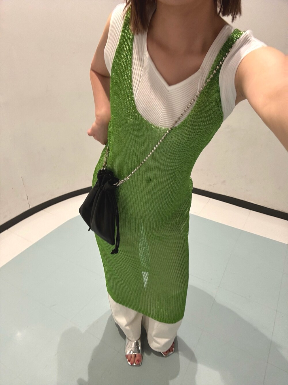 ブラック系のショルダーバッグ、グリーン系のワンピース、シルバー系のサンダルを着用したレディースの夏コーディネートの3枚目の写真