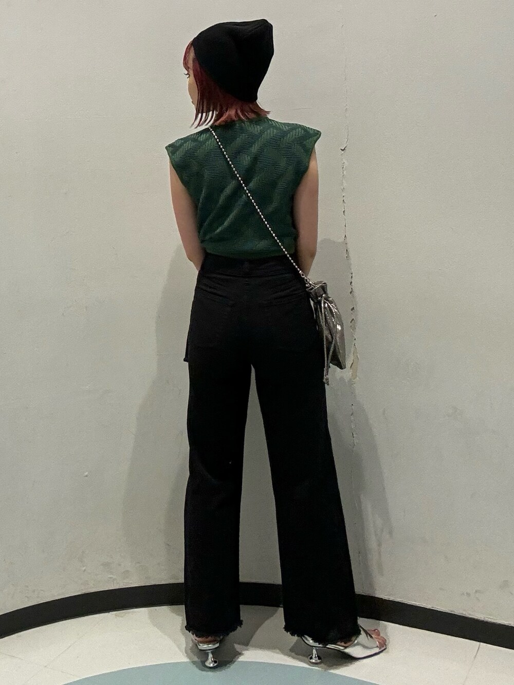 グリーン系のニット/セーター、ブラック系のデニムパンツ、シルバー系のサンダルを着用したレディースの夏コーディネートの3枚目の写真