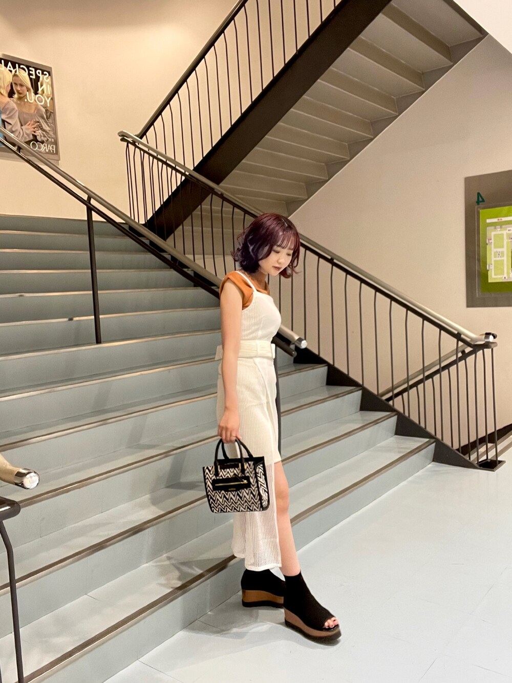 オレンジ系のニット/セーター、その他のショルダーバッグ、ホワイト系のワンピースを着用したレディースの春コーディネートの2枚目の写真