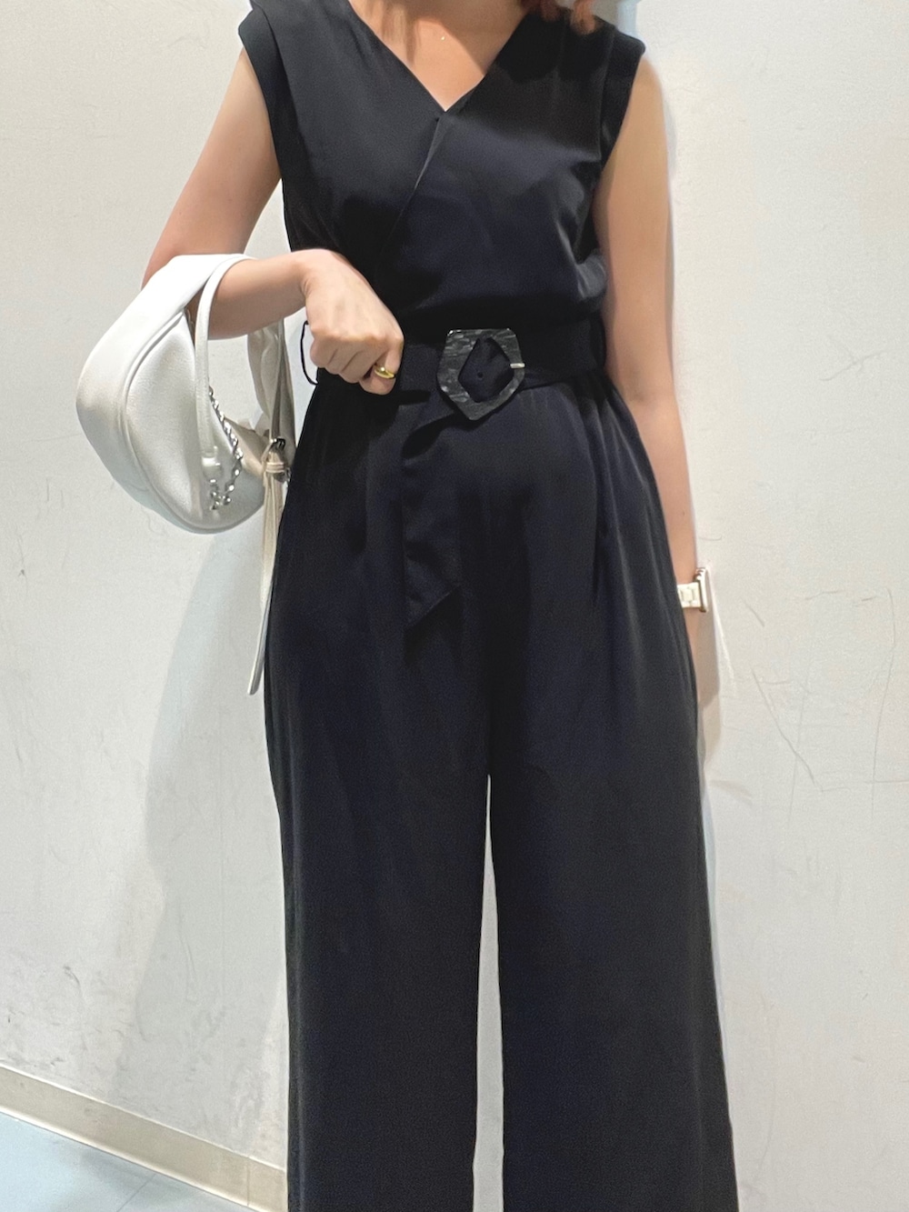 ホワイト系のハンドバッグ、ブラック系のサロペット/オーバーオールを着用したレディースの夏コーディネートの6枚目の写真