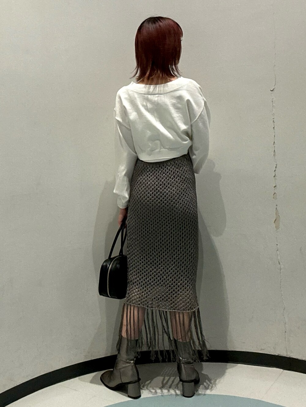 ホワイト系のカーディガン/ボレロ、グレー系のスカート、ブラウン系のブーツを着用したレディースの秋コーディネートの3枚目の写真