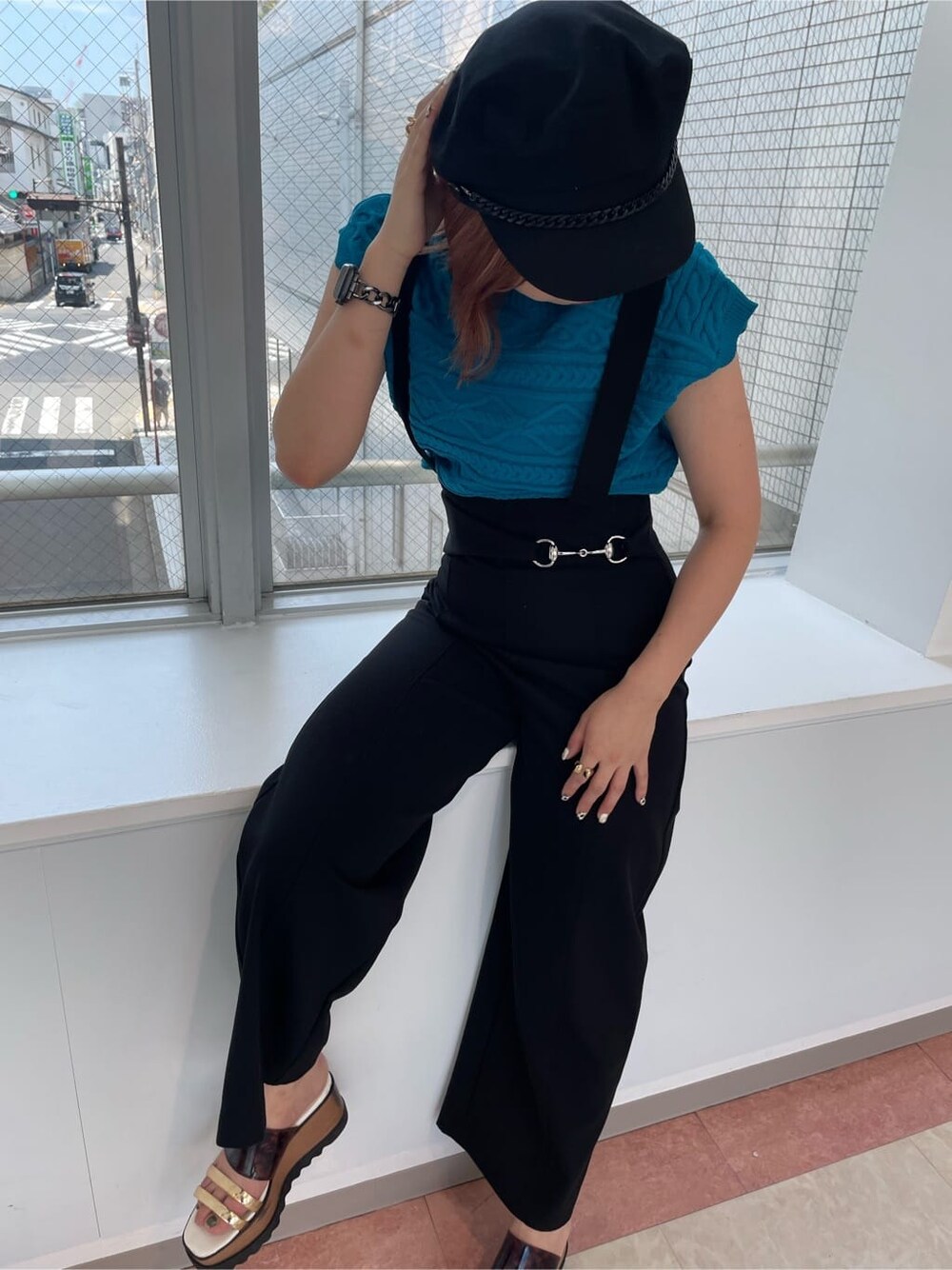 ブルー系のニット/セーター、ホワイト系のブーツ、ブラック系のスラックスを着用したレディースの夏コーディネートの4枚目の写真