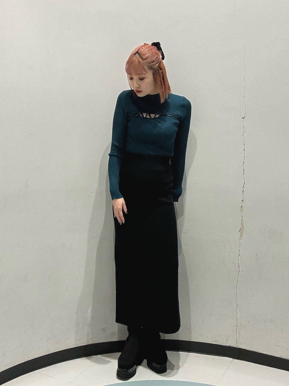 グリーン系のニット/セーター、ホワイト系のブルゾン、ブラック系のスカートを着用したレディースの冬コーディネートの3枚目の写真