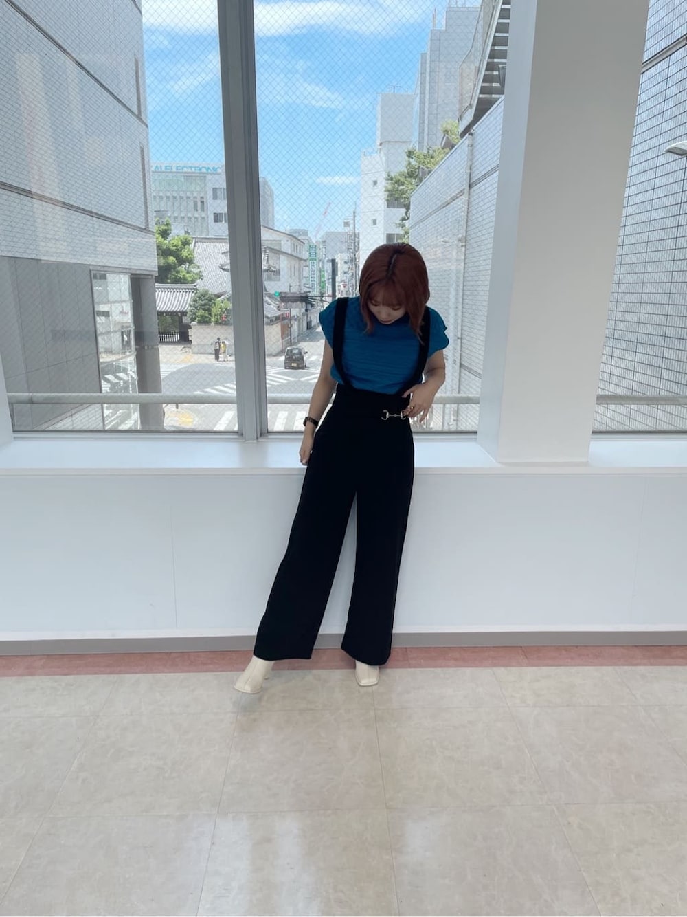 ブルー系のニット/セーター、ホワイト系のブーツ、ブラック系のスラックスを着用したレディースの夏コーディネートの2枚目の写真