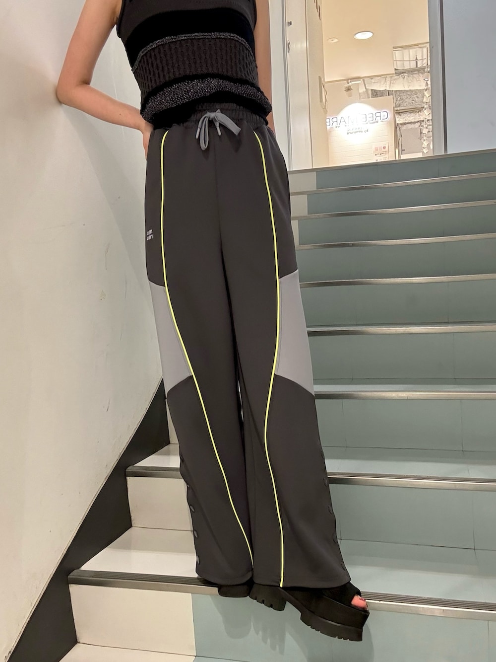 ブラック系のハンドバッグ、ブラック系のニット/セーター、グレー系のその他パンツを着用したレディースの春コーディネートの7枚目の写真