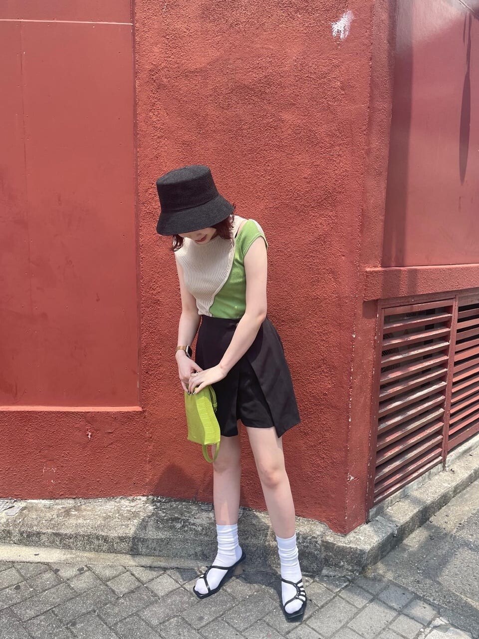 ブラック系のベスト、ブラック系のスラックス、ブラック系のサンダルを着用したレディースの夏コーディネートの3枚目の写真