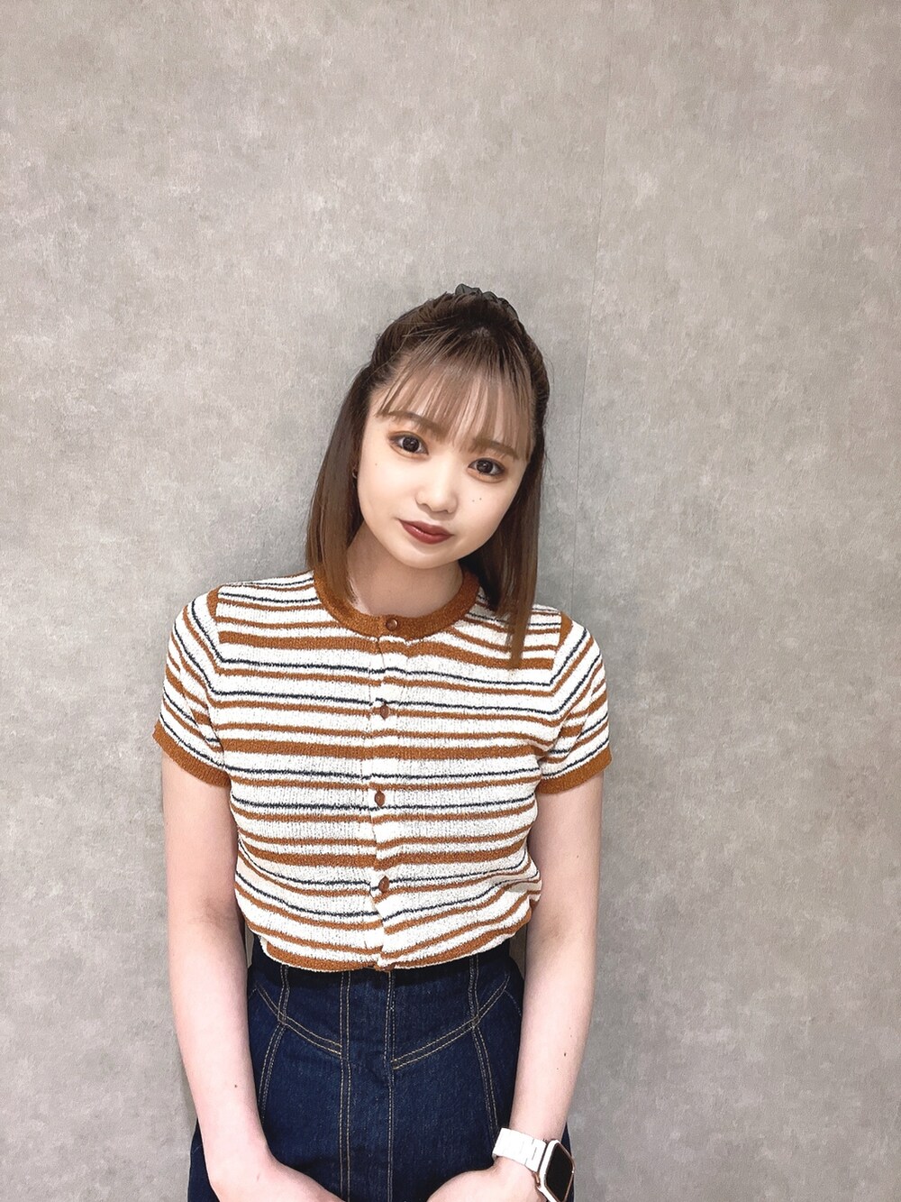 オレンジ系のカーディガン/ボレロ、ホワイト系のデニムスカート、ホワイト系のサンダルを着用したレディースの春コーディネートの4枚目の写真