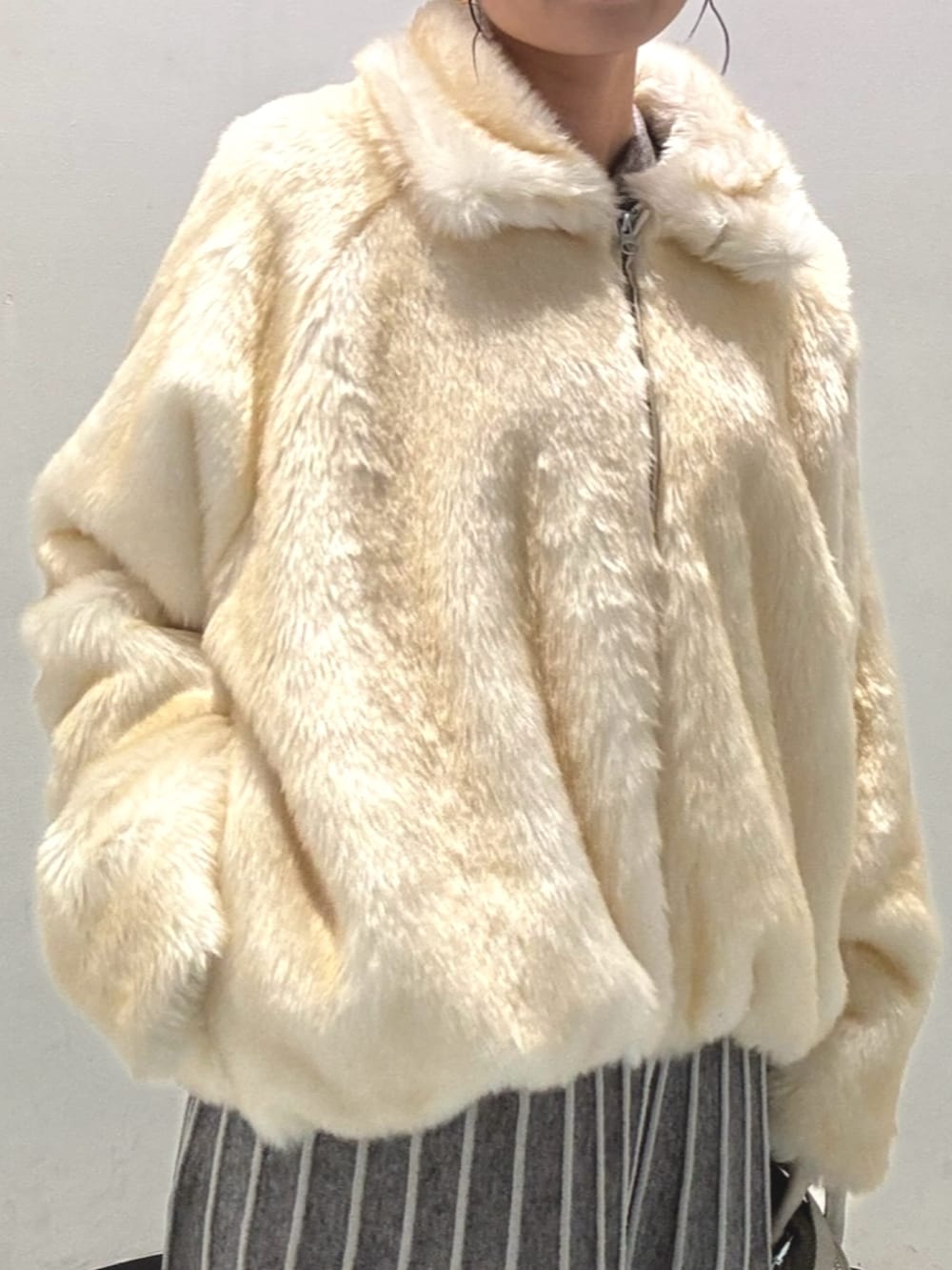 ホワイト系のブルゾン、ホワイト系のハンドバッグ、ブラック系のブーツを着用したレディースの冬コーディネートの5枚目の写真