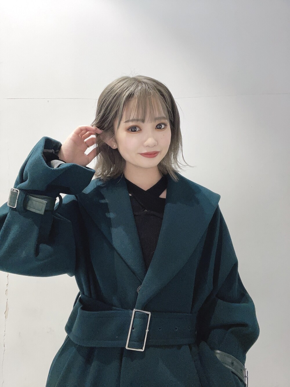 ブラック系のスカート、グリーン系のその他アウター、ブラック系のニット/セーターを着用したレディースの秋コーディネートの2枚目の写真