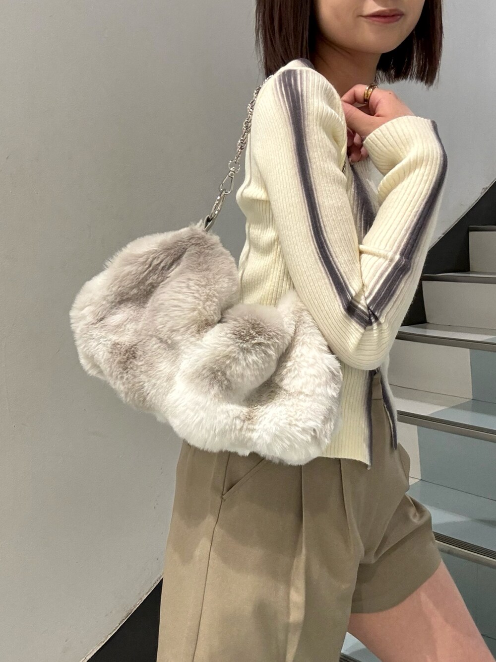 ベージュ系のその他パンツ、ホワイト系のニット/セーター、グレー系のブルゾンを着用したレディースの秋コーディネートの5枚目の写真