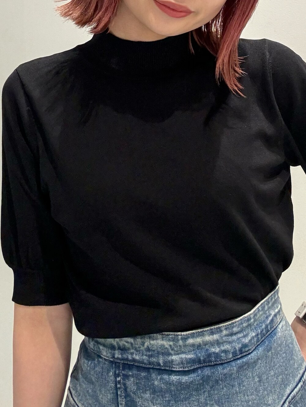 ブラック系のニット/セーター、ブルー系のスカート、ブラック系のブーツを着用したレディースの夏コーディネートの6枚目の写真